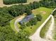 Aerial view showcases wooded property with a long driveway and a traditional home at 3129 Tarheel Clubhouse Road Rd, Raleigh, NC 27604