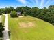 Aerial view of a property showing home, a large open lawn, and surrounding woods at 3129 Tarheel Clubhouse Road Rd, Raleigh, NC 27604