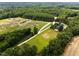 This aerial perspective highlights the estate's home, surrounded by arenas, stables, pastures, and lush greenery at 3129 Tarheel Clubhouse Road Rd, Raleigh, NC 27604