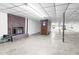 Spacious basement featuring a brick fireplace, concrete floors, and ample room for storage or recreation at 3129 Tarheel Clubhouse Road Rd, Raleigh, NC 27604