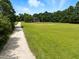 Beautiful home with large, grassy yard, mature trees, and long driveway leading to the residence at 3129 Tarheel Clubhouse Road Rd, Raleigh, NC 27604