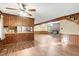 Open living room with wood flooring, a brick fireplace, and a view into the kitchen area at 3129 Tarheel Clubhouse Road Rd, Raleigh, NC 27604