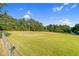 Fenced in large grassy yard with mature trees lining the back of the property at 3129 Tarheel Clubhouse Road Rd, Raleigh, NC 27604