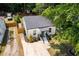 Aerial view of a well-maintained white home with manicured lawn, complemented by a long driveway at 3649 Guess Rd, Durham, NC 27705