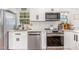 White kitchen features stainless steel appliances, white cabinets, and a granite countertop at 3649 Guess Rd, Durham, NC 27705