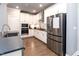 Well-lit kitchen with stainless appliances, white cabinets, and wood floors at 365 Jorpaul Dr, Wake Forest, NC 27587