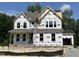New construction home featuring a covered porch, large windows, and a two-car garage at 386 Rising Star Dr, Clayton, NC 27520