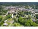 An aerial view of the property highlighted with an arrow, located near a city and surrounded by greenery at 408 N Fourth/ 4Th St, Mebane, NC 27302