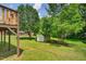 View of the backyard, featuring a small shed and mature trees from the deck with a wooden post at 408 N Fourth/ 4Th St, Mebane, NC 27302