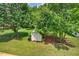 Lush backyard with mature trees and a storage shed for outdoor equipment at 408 N Fourth/ 4Th St, Mebane, NC 27302