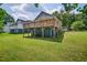 Rear view of house with a spacious wooden deck overlooking the beautifully maintained lawn at 408 N Fourth/ 4Th St, Mebane, NC 27302