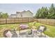 Cozy backyard patio seating area with chairs, pillows, and a modern-style coffee table on lush grass with privacy fence at 418 Magna Dr, Durham, NC 27703