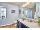 Well-lit bathroom featuring a modern vanity, shower with curtain, and wood-look floors at 418 Magna Dr, Durham, NC 27703