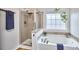 Bathroom featuring a soaking tub, separate shower, and natural light from a frosted window at 418 Magna Dr, Durham, NC 27703