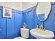 Charming powder room with blue wainscoting, a pedestal sink, and a decorative mirror at 418 Magna Dr, Durham, NC 27703