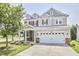 Charming two-story home features a welcoming front porch, a spacious two-car garage, and manicured landscaping at 418 Magna Dr, Durham, NC 27703