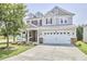 Beautiful two-story home with a well-manicured lawn, stone accents, and a two-car garage at 418 Magna Dr, Durham, NC 27703