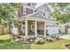 Charming two-story home with a covered porch, featuring stone accents and lush landscaping at 418 Magna Dr, Durham, NC 27703