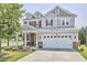 Charming two-story home featuring a manicured lawn and a two-car garage at 418 Magna Dr, Durham, NC 27703