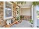 Welcoming front porch showcasing a stone facade, potted plants, and a wooden bench creating a cozy entrance at 418 Magna Dr, Durham, NC 27703