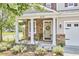 Inviting front porch featuring stone accents, white columns and manicured garden at 418 Magna Dr, Durham, NC 27703