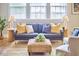 Bright living room with a blue sofa with decorative pillows and ottoman on a jute rug at 418 Magna Dr, Durham, NC 27703