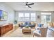 Bright living room featuring a ceiling fan, comfortable seating, and natural light from the large window at 418 Magna Dr, Durham, NC 27703