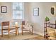 Bright office space featuring two chairs, a table with a lamp, and a bookshelf with decorative items and natural lighting at 418 Magna Dr, Durham, NC 27703