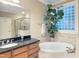 Luxurious bathroom with a soaking tub, glass-enclosed shower, and a vanity with granite countertop at 4416 Brighton Ridge Dr, Apex, NC 27539