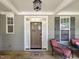 Charming front porch with wood door, welcome mat, and cozy seating area at 4416 Brighton Ridge Dr, Apex, NC 27539