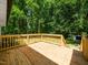 A spacious wooden deck with railing overlooks the lush, green backyard at 4428 W West River Rd, Franklinton, NC 27525