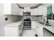 Well-lit kitchen featuring modern appliances, white cabinets, and sleek countertops at 4428 W West River Rd, Franklinton, NC 27525