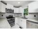 Clean kitchen featuring white cabinets, a stainless steel range and sink, and ample counter space at 4428 W West River Rd, Franklinton, NC 27525
