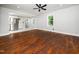 Sun-filled living area with hardwood floors, a ceiling fan, and open access to the modern kitchen at 4428 W West River Rd, Franklinton, NC 27525