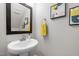 Stylish half bathroom featuring pedestal sink, decorative mirror, and modern artwork at 444 Claremont Dr, Chapel Hill, NC 27516