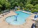 Aerial view of community pool with various seating options including sun loungers and shaded tables with umbrellas at 444 Claremont Dr, Chapel Hill, NC 27516