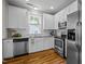 Modern kitchen boasts stainless steel appliances, white cabinetry, subway tile backsplash, and granite countertops at 444 Claremont Dr, Chapel Hill, NC 27516