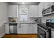 Bright kitchen features white cabinets, stainless steel appliances, granite countertops, and wood-look flooring at 444 Claremont Dr, Chapel Hill, NC 27516