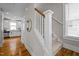 Inviting staircase with carpeted steps, white banister, and hardwood flooring in the entryway at 444 Claremont Dr, Chapel Hill, NC 27516