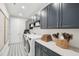 Well-organized laundry room with blue cabinets, quartz countertops, and modern appliances at 45 Shady Creek Way, Fuquay Varina, NC 27526