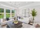 Bright living room with large windows, white sofas, modern decor, and plenty of natural light at 45 Shady Creek Way, Fuquay Varina, NC 27526