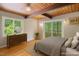 Bedroom with wood ceilings, wood floors, large windows, and decorative bedside furnishings at 4501 Zebulon Rd, Zebulon, NC 27597