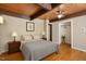 Comfortable bedroom features wood-beam ceiling, and hardwood flooring at 4501 Zebulon Rd, Zebulon, NC 27597