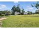 Spacious backyard featuring a shed, mature trees, and lush green lawn, perfect for outdoor activities at 456 Majestic Oak Dr, Garner, NC 27529
