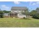 Backyard view of a two-story home with a screened-in porch, a well-maintained lawn, and a beautiful tree at 456 Majestic Oak Dr, Garner, NC 27529
