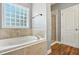 This bathroom boasts a soaking tub, a window, and a separate glass-enclosed shower at 456 Majestic Oak Dr, Garner, NC 27529