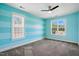 This bedroom features striped walls, two windows, carpet, and a ceiling fan at 456 Majestic Oak Dr, Garner, NC 27529