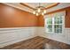 Elegant dining room with wood floors, wainscoting, modern lighting, and a large window at 456 Majestic Oak Dr, Garner, NC 27529