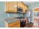 Modern kitchen boasting stainless steel appliances, granite counters, and wooden cabinetry at 456 Majestic Oak Dr, Garner, NC 27529