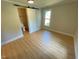 Bedroom with light colored walls and wood floor, sliding door to bath, window to backyard at 510 May St, Gibsonville, NC 27249